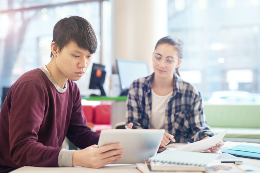Young man using tablet pc in study